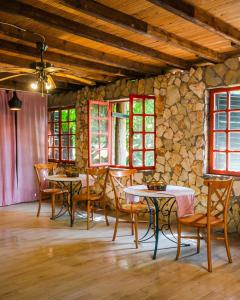 a room with tables and chairs and a stone wall at Kadir's Family House in Olympos