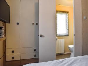 a bedroom with a white cabinet and a toilet at Bluebird in Prestatyn
