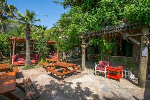 a patio with wooden tables and chairs in front of a building at Kadir's Family House in Olympos