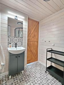 a bathroom with a sink and a wooden door at Domek nad Dadajem in Kromerowo