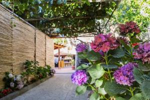 einen Garten mit lila Blumen und einem Gehweg in der Unterkunft Villa La Natura x9 Whole villa with private parking in Sorrent