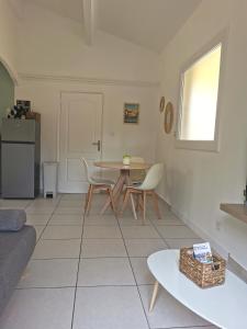 een woonkamer met een tafel en stoelen bij Charmant T2 avec extérieur au cœur du Vaucluse in Châteauneuf-de-Gadagne