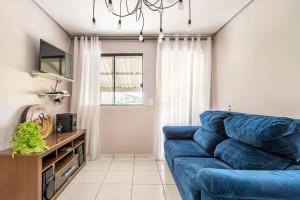 a living room with a blue couch and a window at CASA SERRA CATARINENSE in Rio Rufino