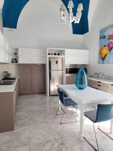 a kitchen with a white table and blue chairs at Suite in centro in Galatina