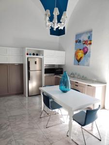 a white kitchen with a white table and chairs at Suite in centro in Galatina