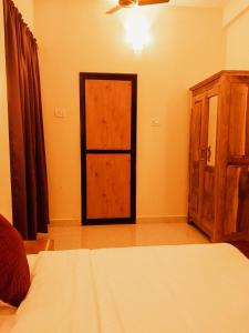 1 dormitorio con 1 cama y armario de madera en Casa De Menorah, en Nerul