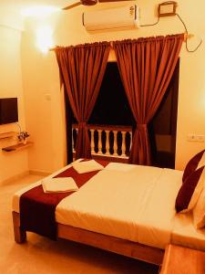 um quarto com uma cama e uma janela com cortinas em Casa De Menorah em Nerul