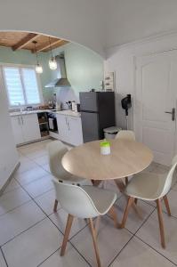 een keuken met een tafel en stoelen bij Charmant T2 avec extérieur au cœur du Vaucluse in Châteauneuf-de-Gadagne