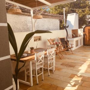 un patio con mesa de madera y sillas en Babushka Apartments, en Olympiada