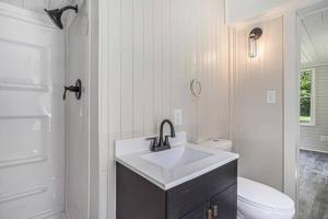 La salle de bains blanche est pourvue d'un lavabo et de toilettes. dans l'établissement Pickleball Paradise, à South Haven