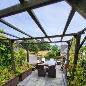 a pergola with a table and chairs on a patio at Aremo Room 1 in Torquay