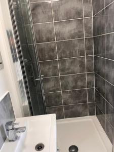 a bathroom with a sink and a shower at The Serviced Accommodations in Harlow