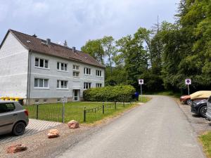 una casa con coches aparcados al lado de una carretera en happyhome mitten im HARZ - direkte Wanderwege - Bachplätschern - Küche - Kinderfreundlich - Paare und Freunde en Elend