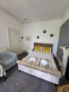 a bedroom with a large bed with yellow pillows at Aremo Room 1 in Torquay