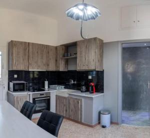 a kitchen with wooden cabinets and a light fixture at St' Amiralidika Houses in Kómi