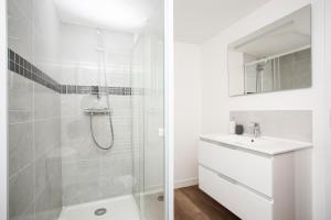 La salle de bains blanche est pourvue d'une douche et d'un lavabo. dans l'établissement AmorAmor ~ T2 Romantique, à Vierzon
