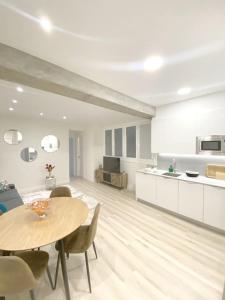 een woonkamer met een tafel en een keuken bij ALBAOLA APARMENT in San Sebastian