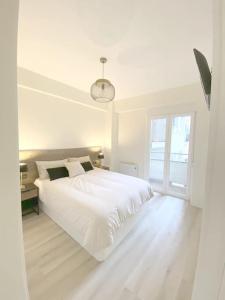 - une chambre blanche avec un lit blanc et une fenêtre dans l'établissement ALBAOLA APARMENT, à Saint-Sébastien