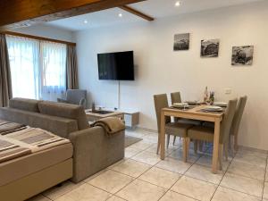 una sala de estar con un sofá y una mesa en Apartments Arcadia, en Saas-Grund