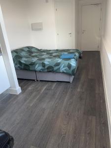 a bedroom with two beds and a wooden floor at The Serviced Accommodations in Harlow