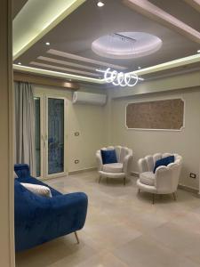 Sheikh Zayed的住宿－Modern and spacious duplex，客厅配有两把椅子和蓝色沙发