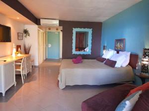 een grote slaapkamer met een groot bed en een bureau bij ILET BLEU studio cosy RDC vue mer et jardin - Accès direct plage in Le Gosier