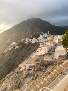 a village on a hill with a mountain in the background at Oxo Kamara Apartment in Karpathos Town