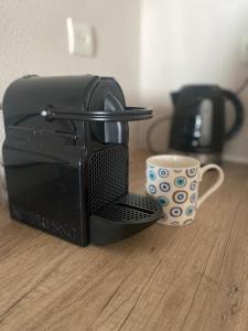 a black microwave sitting on a table next to a cup at Oxo Kamara Apartment in Karpathos Town