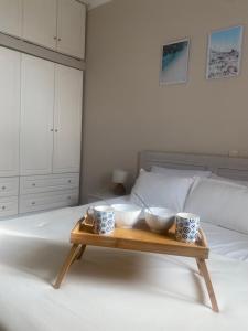 a wooden tray with three bowls on a bed at Oxo Kamara Apartment in Karpathos Town