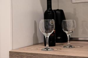 twee wijnglazen zittend op een tafel met een fles wijn bij Apartments Kolovrat in Podstrana