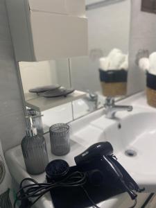 una cámara sentada en un lavabo frente a un espejo en Oxo Kamara Apartment en Kárpatos