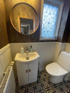 a bathroom with a sink and a toilet and a mirror at Villa Rydholm 15 minutes from Gothenburg Center in Gothenburg