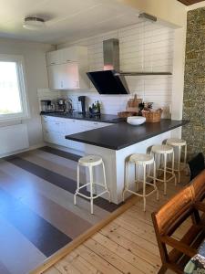 a kitchen with a black counter and stools in it at Villa Rydholm 15 minutes from Gothenburg Center in Gothenburg