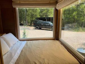 une fenêtre dans une chambre avec un camion garé à l'extérieur dans l'établissement HiddenAcres Cabin - woodsy private couples retreat, à Eustace