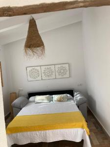 1 dormitorio con 1 cama con manta amarilla en Finca el atardecer - Apartamento Sol, en Los Santos de Maimona