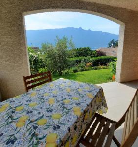 een tafel en stoelen op een balkon met uitzicht op de bergen bij Le Lac in Tresserves