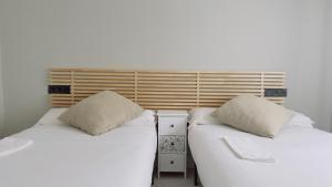 dos camas sentadas una al lado de la otra en una habitación en Plentzia, junto al puerto (garaje opcional), en Plentzia