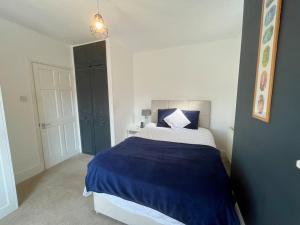 um quarto com uma cama azul e branca com um cobertor azul em Woodside Road, Southbourne em Bournemouth