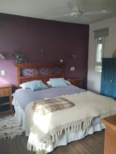 sypialnia z dużym łóżkiem i fioletowymi ścianami w obiekcie Casa frente al golf w mieście La Cumbre