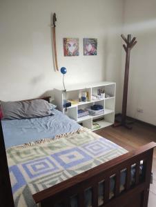 sypialnia z łóżkiem i półką na książki w obiekcie Casa frente al golf w mieście La Cumbre