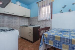 a kitchen with a table and a sink and a stove at Holiday Home Lovric in Filipac