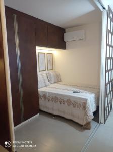 um pequeno quarto com uma cama e um closet em Loft Encantador, a beira mar! em Salvador