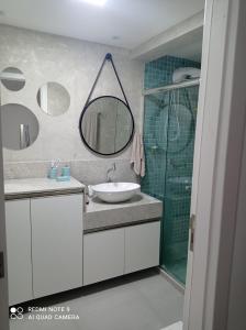 uma casa de banho com um lavatório e um espelho em Loft Encantador, a beira mar! em Salvador