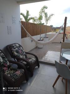 a room with two chairs and a hammock on a balcony at Loft Encantador, a beira mar! in Salvador