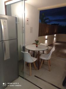 uma cozinha com uma mesa e cadeiras e um frigorífico em Loft Encantador, a beira mar! em Salvador