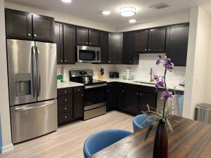 a kitchen with stainless steel appliances and a wooden table at Vista Cay Condo near Conventional Center Universal, See world, Disney 8 in Orlando