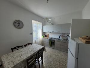 a kitchen with a table with chairs and a refrigerator at Ca' du Bertu in San Bartolomeo