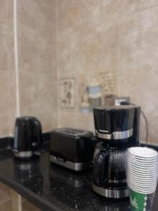 a counter with a coffee maker and cups on it at Modern and spacious duplex الشيخ زايد in Sheikh Zayed