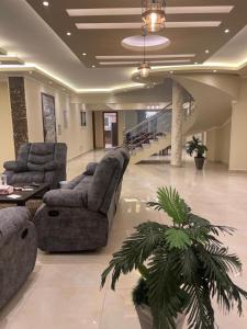 a lobby with couches and a plant in the middle at Modern and spacious duplex الشيخ زايد in Sheikh Zayed