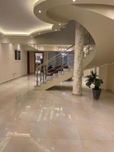 a large lobby with a staircase in a building at Modern and spacious duplex الشيخ زايد in Sheikh Zayed